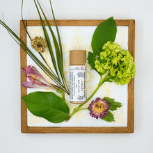 Load image into Gallery viewer, Eye Balm product surrounded by flowers.
