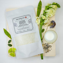 Load image into Gallery viewer, &quot;Goat Milk Magnesium Bath Salts&quot; surrounded by a glass of milk and leaves.
